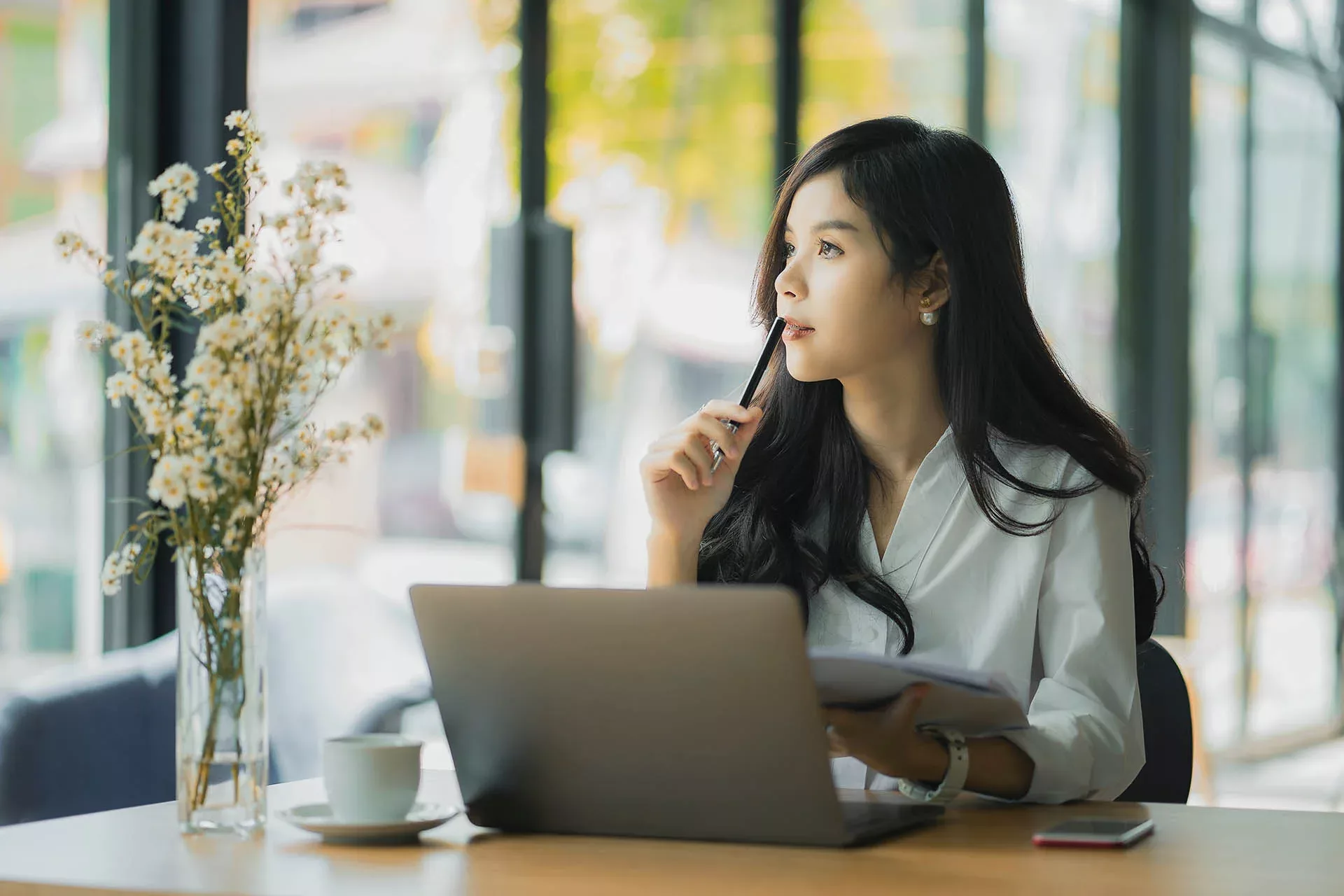 Woman ponders while using laptop