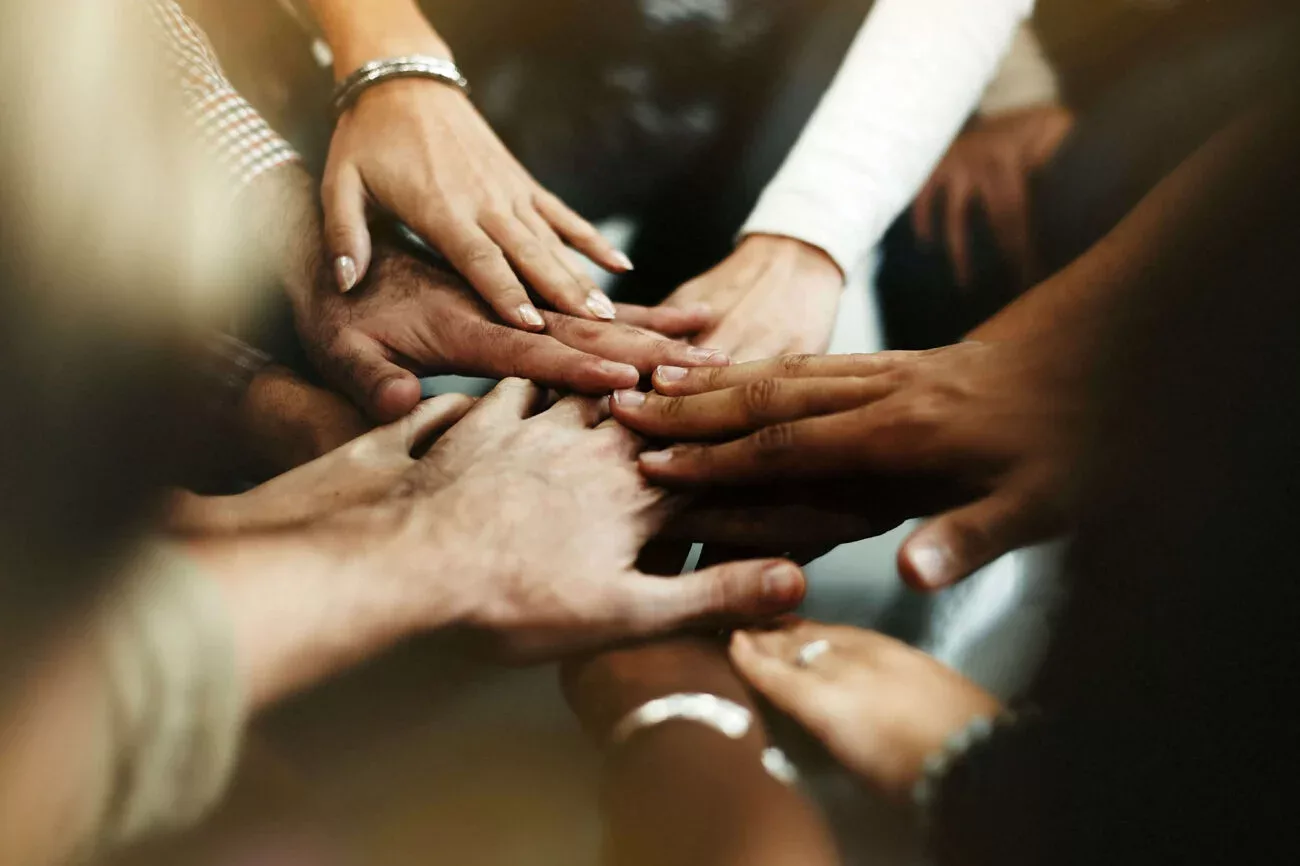 Diverse office hands celebrating